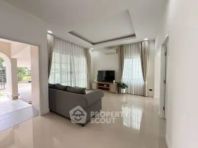 Spacious living room with modern decor and large windows for natural light.