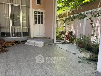 Charming patio with tiled flooring and lush greenery, perfect for outdoor relaxation and entertaining.
