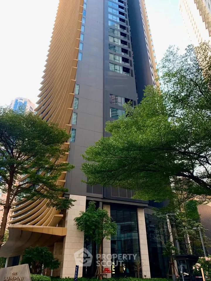 Stunning modern high-rise building with unique architectural design and lush greenery.