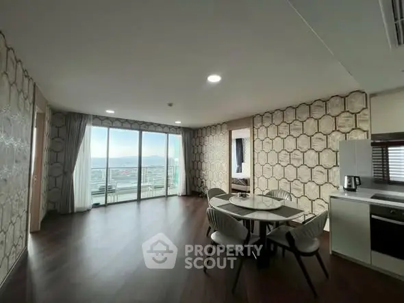 Spacious modern living room with stunning sea view and elegant dining area.
