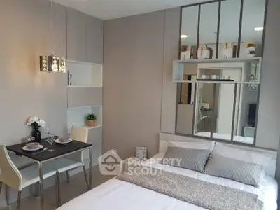 Modern studio apartment with cozy bedroom and dining area, featuring stylish decor and ample storage.