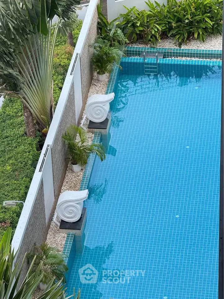 Luxurious outdoor pool with elegant design and lush greenery, perfect for relaxation and leisure.