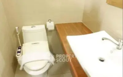 Compact bathroom with modern fixtures and wooden countertop