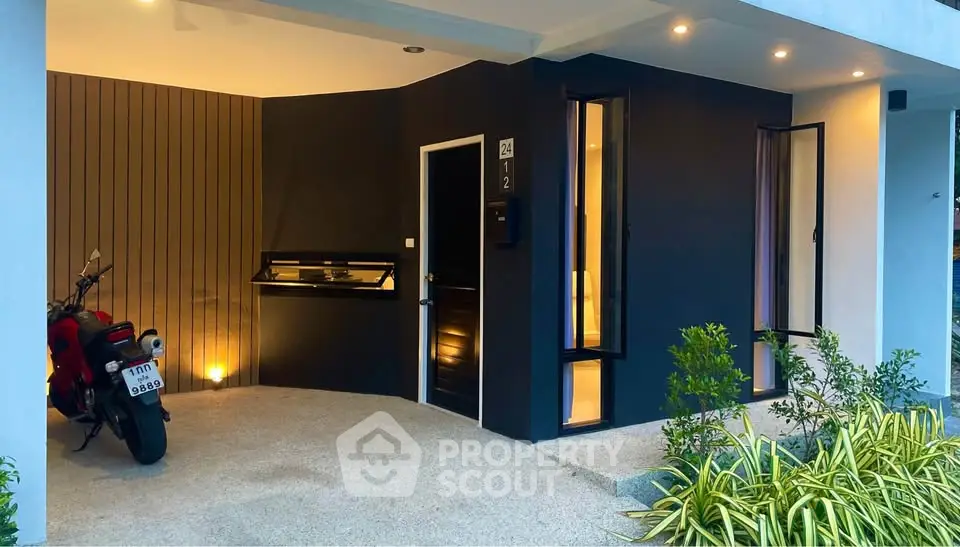 Modern exterior view of a stylish home entrance with sleek design and motorcycle parked outside.