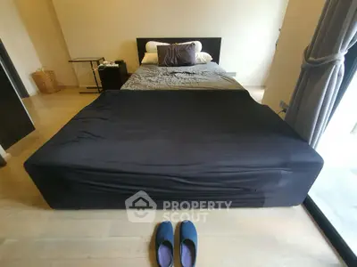 Spacious bedroom with modern decor and large window for natural light.