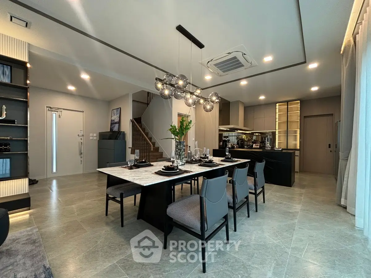 Spacious modern dining area with elegant lighting and open kitchen layout
