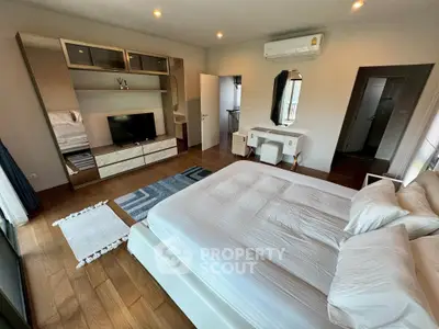 Spacious modern bedroom with wooden flooring and elegant furnishings