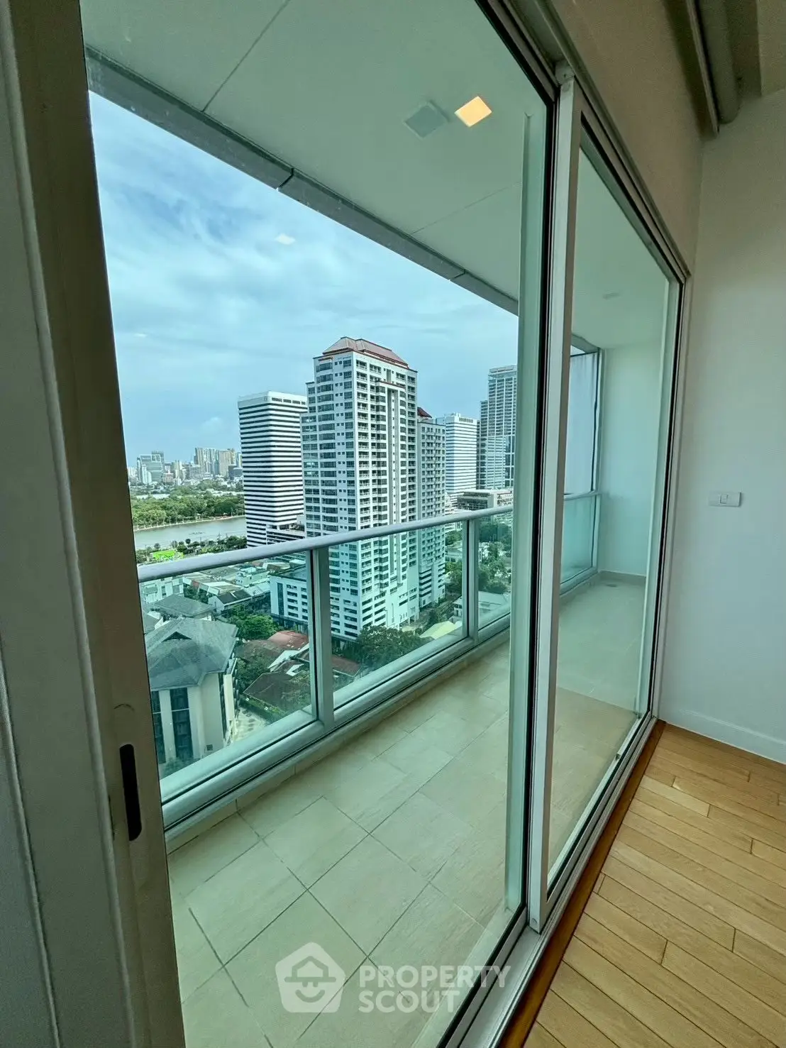Stunning high-rise balcony view with cityscape and modern glass doors.