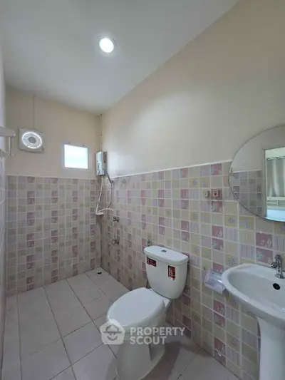 Charming bathroom with pastel tile accents and modern fixtures.