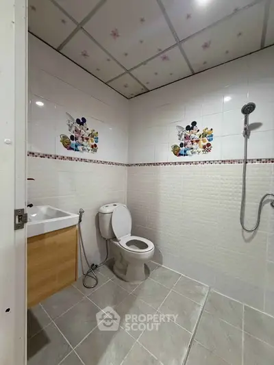 Modern bathroom with decorative tiles and shower in a real estate property.