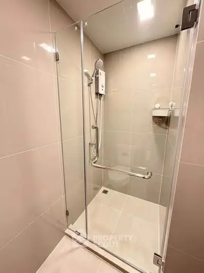 Modern bathroom with sleek glass shower enclosure and elegant tile design.
