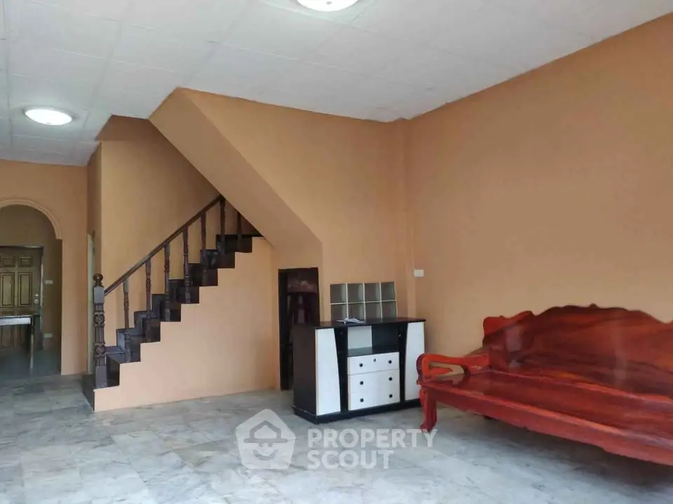 Spacious living room with elegant wooden furniture and staircase