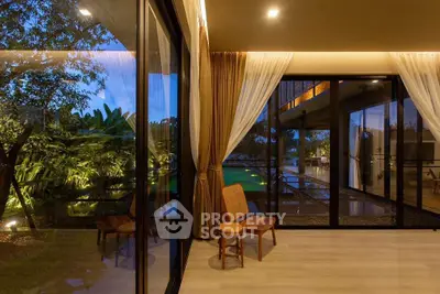 Luxurious modern living room with floor-to-ceiling windows overlooking a serene garden and pool.