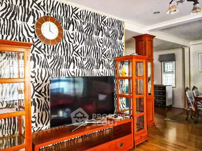 Stylish living room with zebra print accent wall and modern TV setup