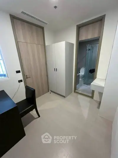 Modern minimalist bedroom with ensuite bathroom and sleek furniture design.
