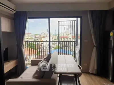 Modern living room with city view and balcony access in urban apartment.
