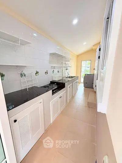 Modern kitchen with sleek white cabinetry and ample natural light