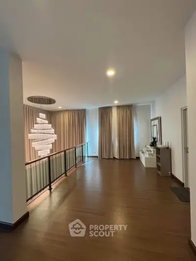 Spacious modern living area with elegant lighting and wooden flooring