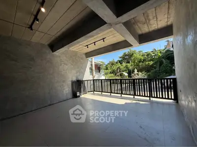 Spacious modern balcony with concrete ceiling and scenic garden view
