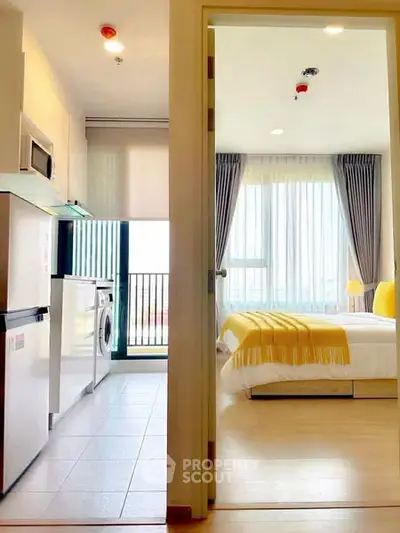 Modern apartment with open kitchen and cozy bedroom, featuring large windows and stylish decor.