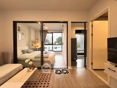 Modern apartment interior with cozy bedroom and stylish living area, featuring large windows and elegant decor.