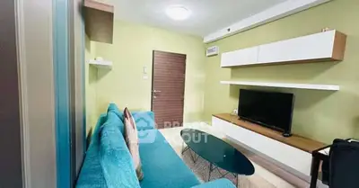 Modern living room with stylish furniture and wall-mounted TV in a cozy apartment.