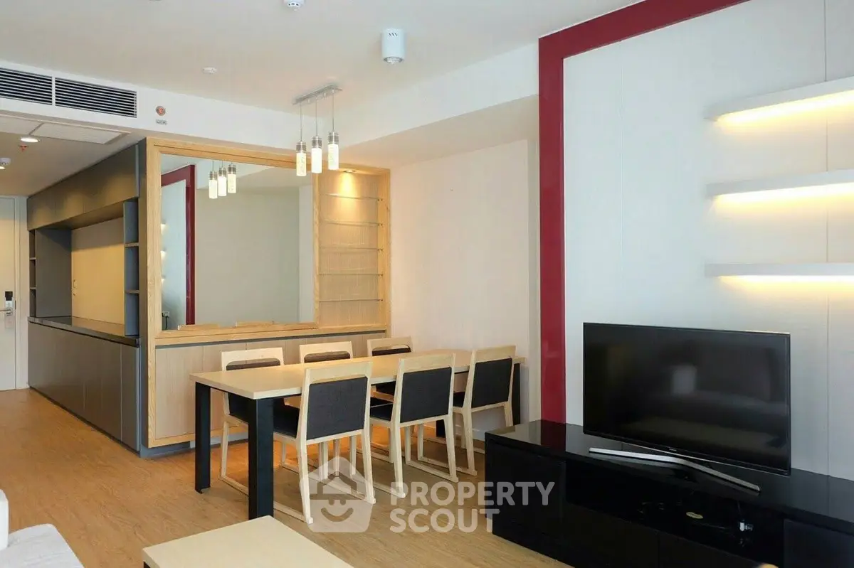 Modern living room with dining area, sleek furniture, and stylish lighting in a contemporary apartment.