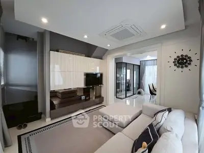 Modern living room with stylish decor and open layout, featuring a cozy sectional sofa and sleek entertainment center.
