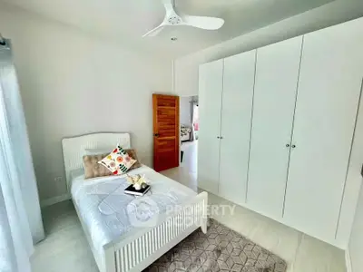 Bright and cozy bedroom with modern white wardrobe and stylish decor