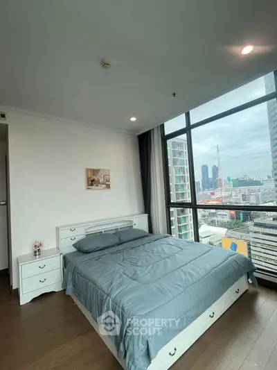 Spacious bedroom with city view in modern high-rise apartment