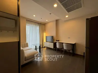 Modern living room with stylish furniture and large window offering natural light.