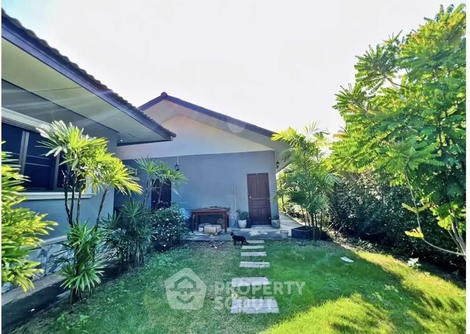 Charming garden view of a suburban home with lush greenery and pathway.