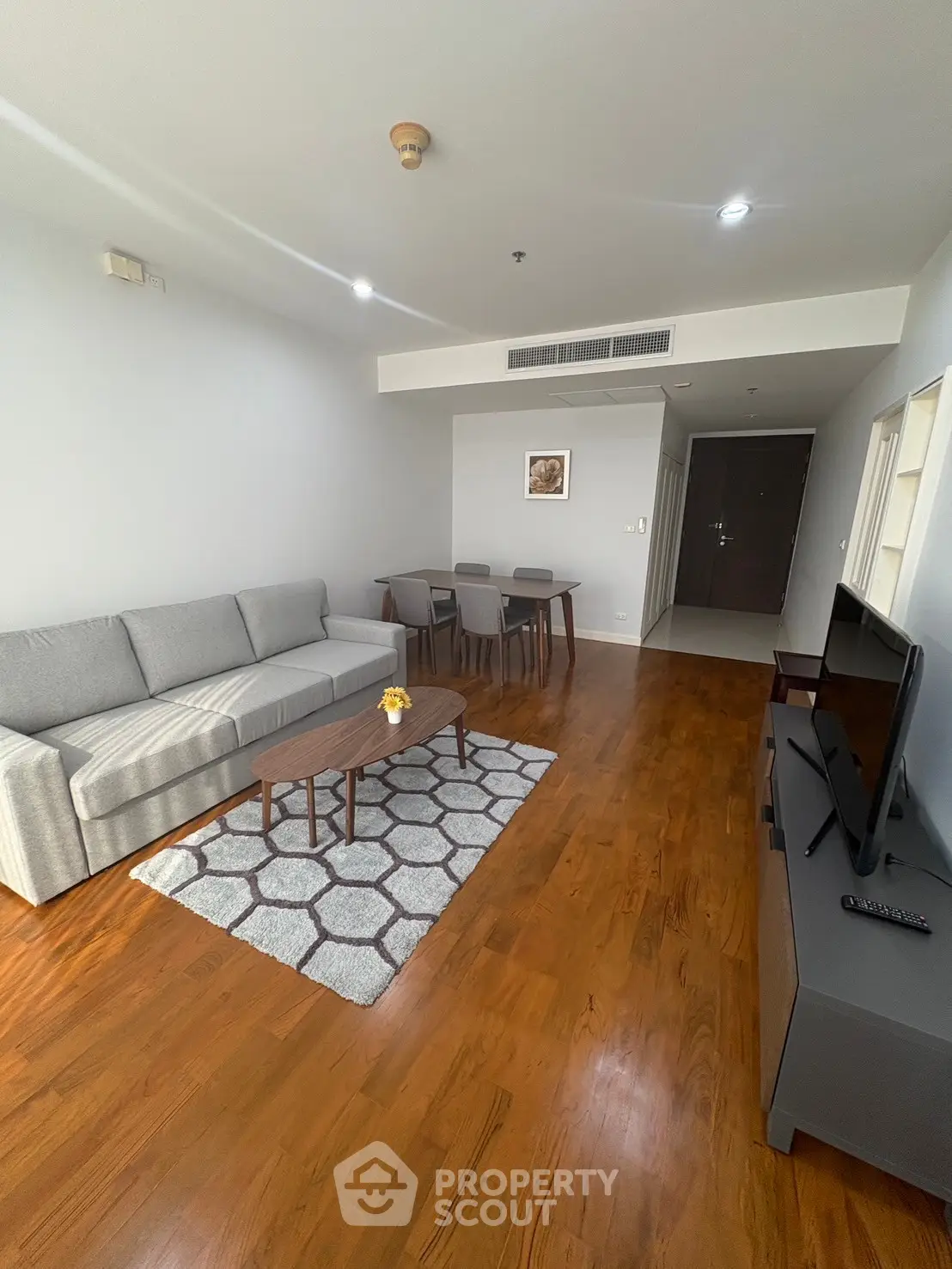 Spacious modern living room with wooden flooring and stylish furniture