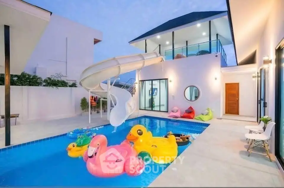 Luxurious modern villa with private pool and fun water slide, perfect for family entertainment.