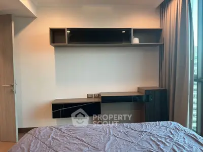 Modern bedroom with sleek built-in storage and large window view