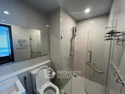 Modern bathroom with glass shower and sleek fixtures in a contemporary home.