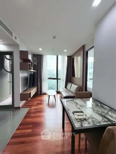 Modern living room with wooden flooring and large window offering city view