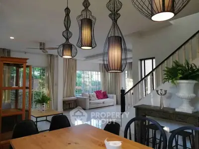 Spacious living room with modern lighting and elegant decor, perfect for family gatherings.