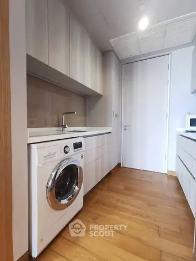 Modern kitchen with sleek cabinetry and built-in washing machine