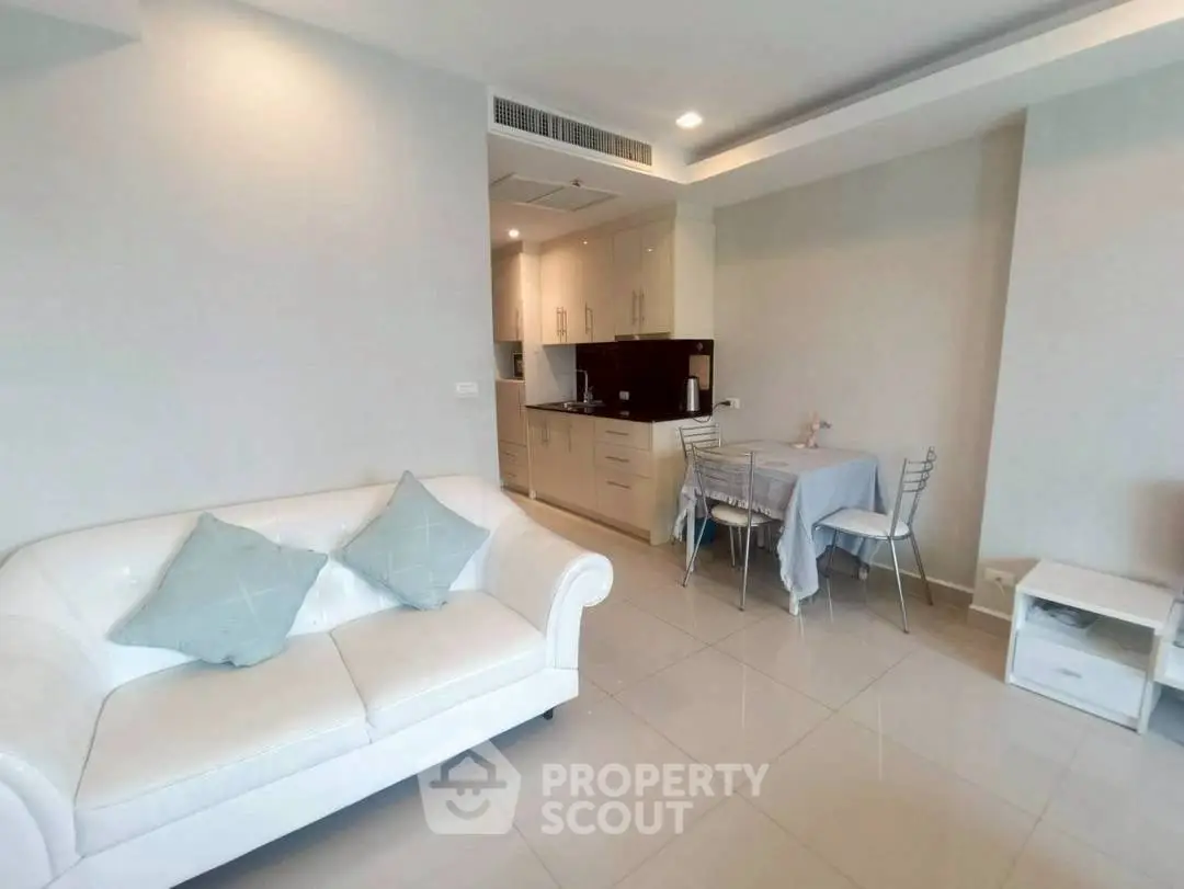 Modern living room with cozy white sofa and compact kitchen area