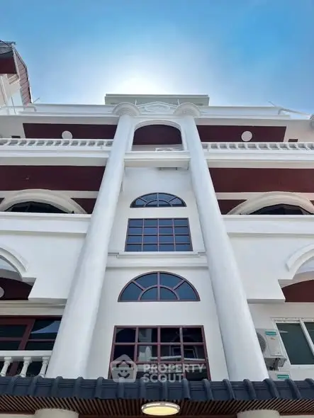 Stunning architectural facade of modern multi-story building with elegant columns and arched windows.