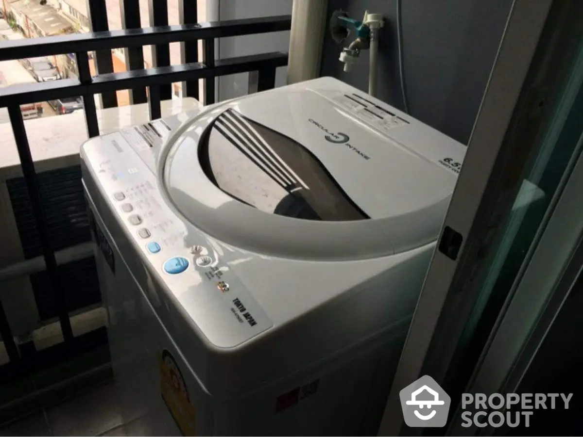 Modern washing machine on apartment balcony with city view