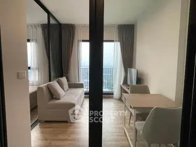 Modern living room with balcony view, stylish furniture, and natural light in a high-rise apartment.