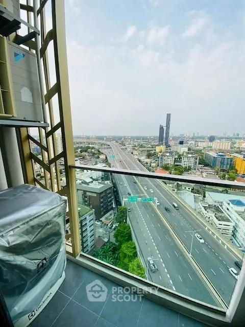 Stunning high-rise balcony view overlooking cityscape and highway, perfect for urban living.