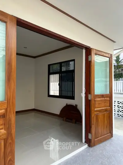Spacious entryway with wooden doors and tiled flooring in modern home