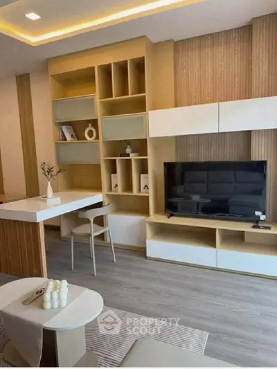 Modern living room with stylish shelving and flat-screen TV, featuring contemporary furniture and decor.