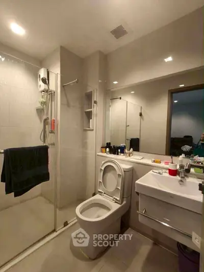 Modern bathroom with glass shower and sleek fixtures in a contemporary apartment.