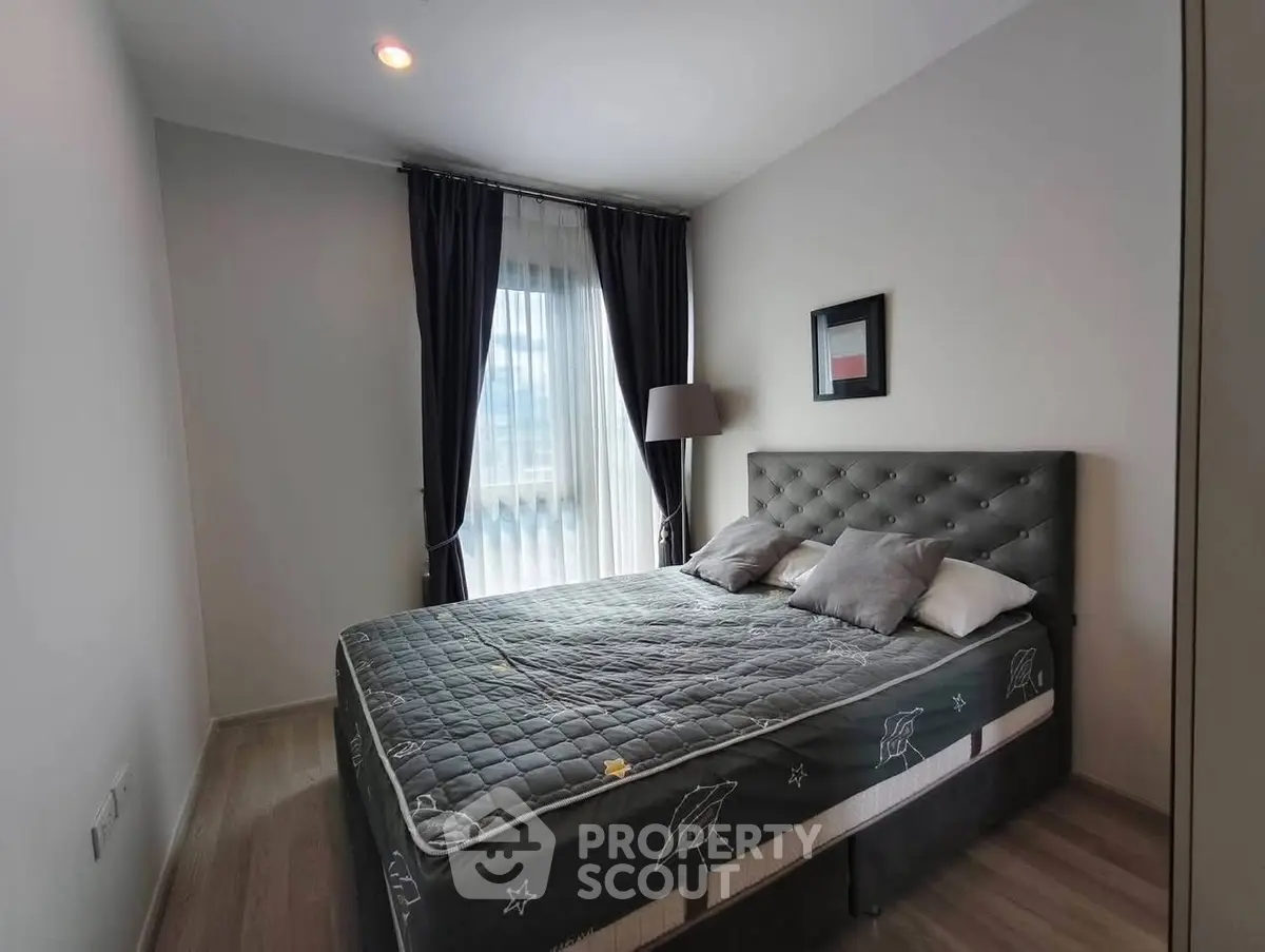 Cozy bedroom with modern decor and large window for natural light