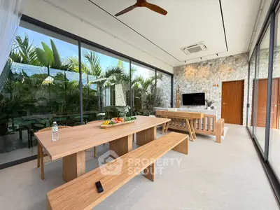 Luxurious modern living room with glass walls and garden view, featuring elegant wooden furniture.