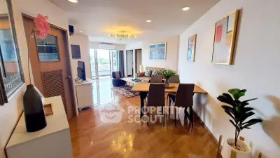 Spacious living room with modern decor and large windows offering natural light and city views.
